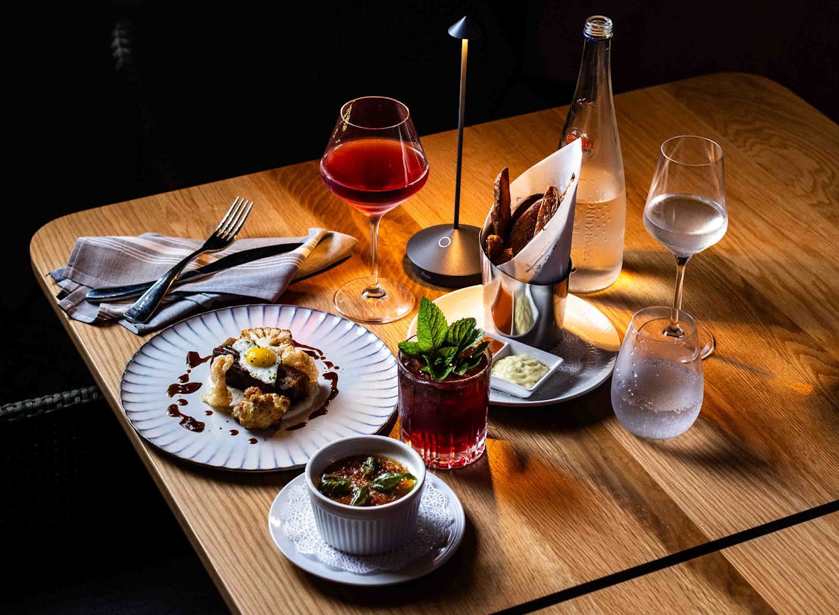 a glass of wine sitting on top of a wooden table