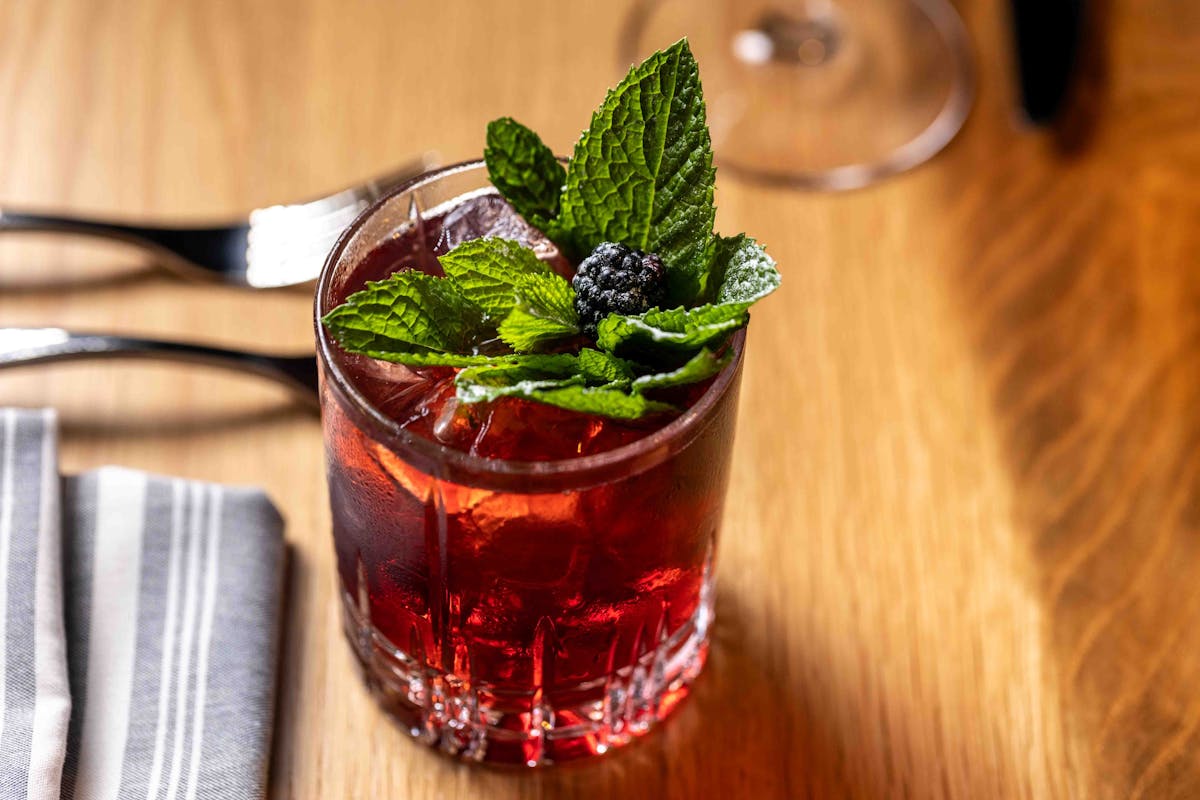 a glass of wine sitting on top of a wooden table